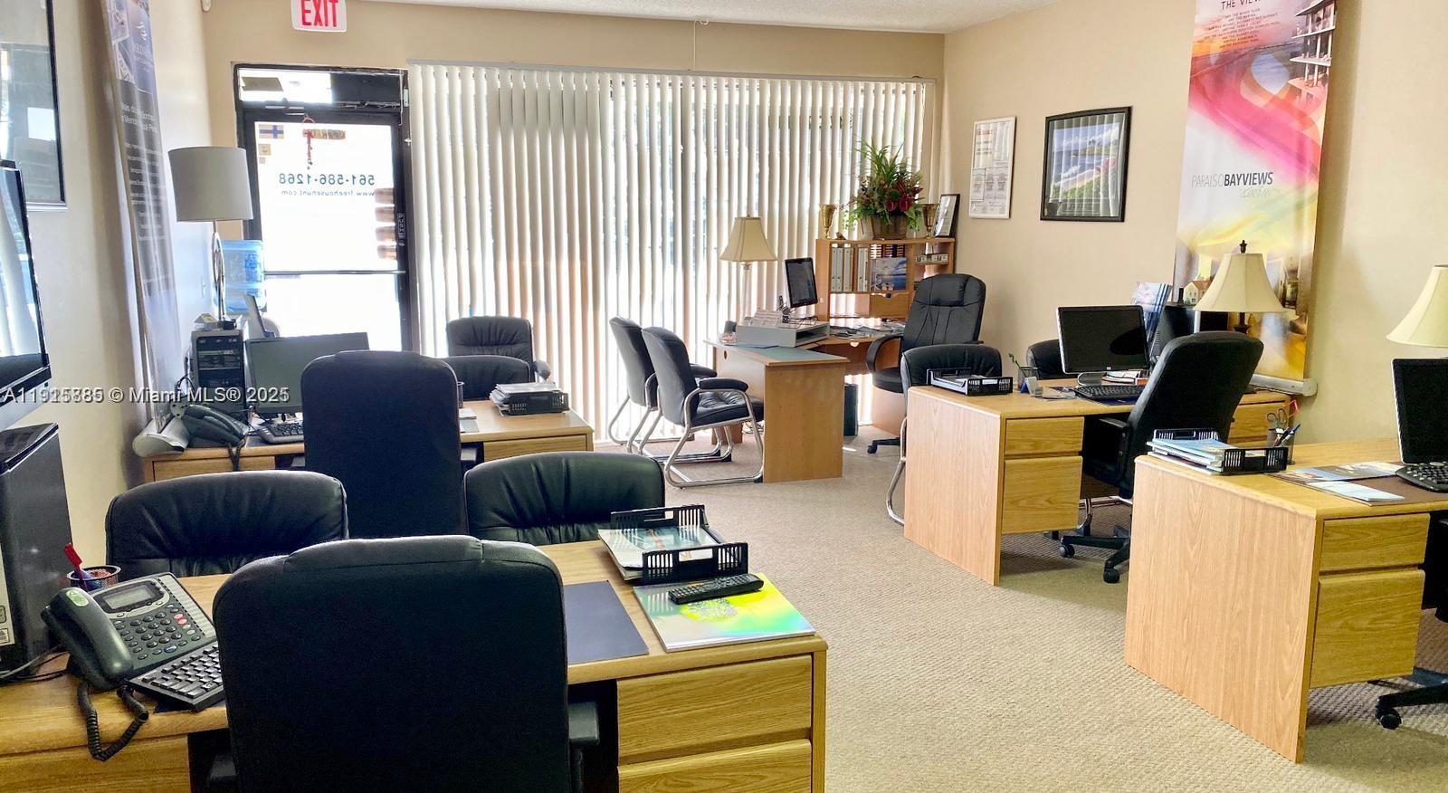 An office space features multiple wooden desks, black chairs, and vertical blinds covering a window — 934 S Dixie, Lantana FL 33462, LANTANA, FL