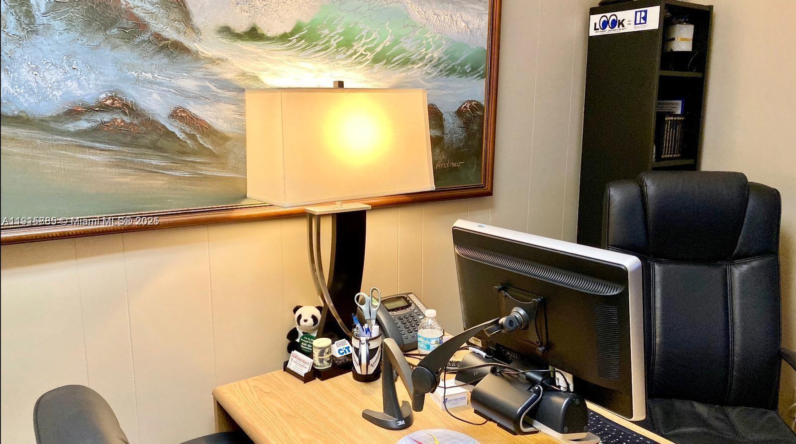 An office space features a desk with a computer monitor, lamp, and a wall painting — 934 S Dixie, Lantana FL 33462, LANTANA, FL