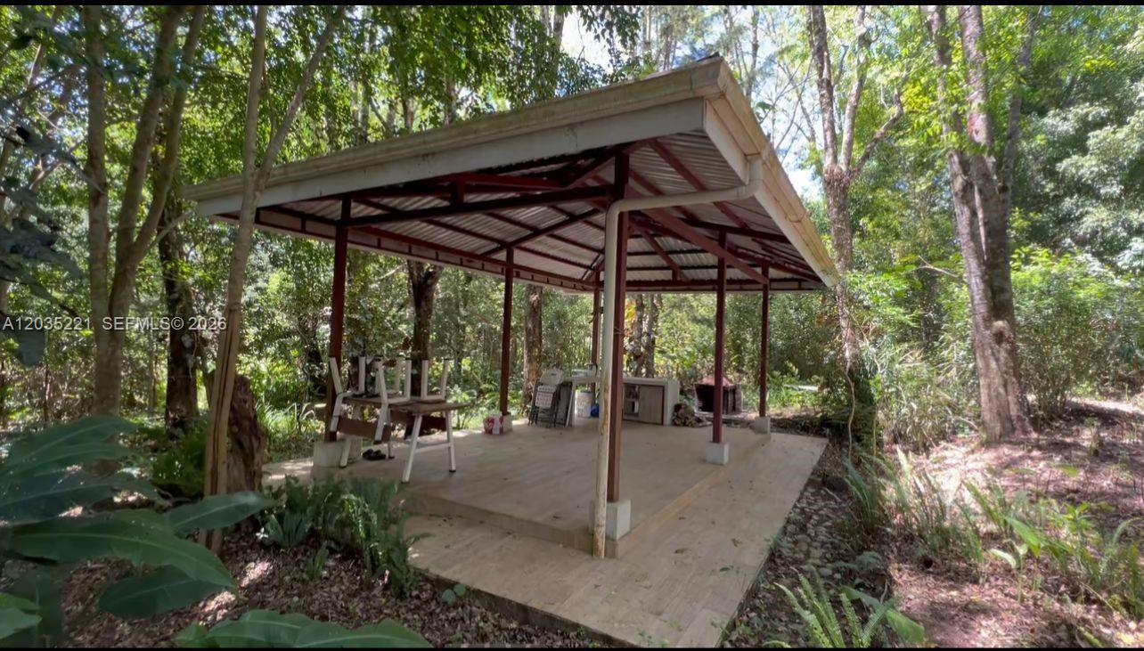 An open-air wooden gazebo with a tiled floor sits in a wooded area — SAN RAFAEL CASA No usar, FL, FL