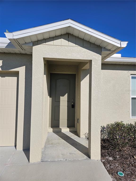 The exterior of a house features a tan front door under a covered entryway — 901 NW 15TH PLACE, CAPE CORAL, FL
