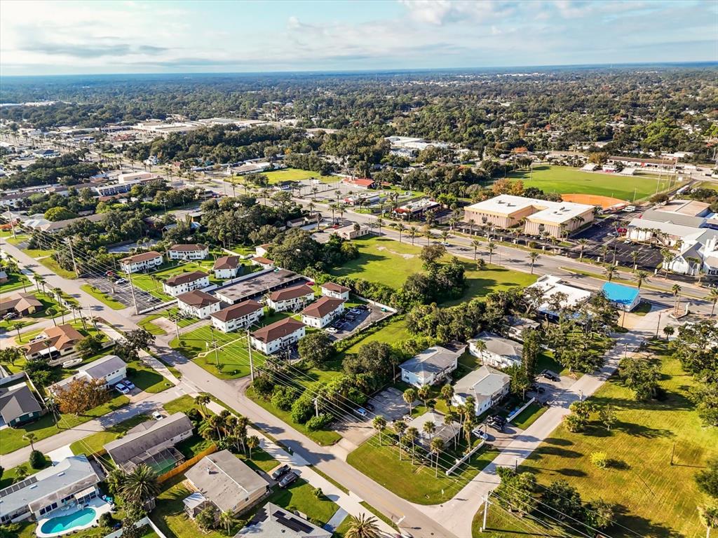 An aerial view shows a suburban neighborhood with residential buildings, green spaces, and a road — 1771 S RIDGEWOOD AVENUE, SOUTH DAYTONA, FL