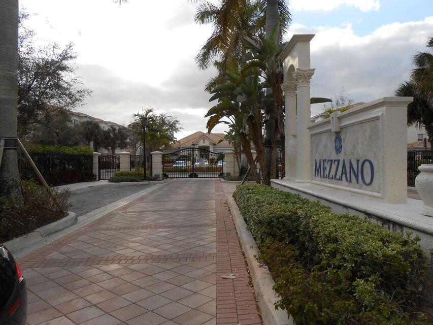 A paved driveway leads to the gated entrance of a residential community named Mezzano — 9905 Baywinds Boulevard # 2202, West Palm Beach FL 33411, WEST PALM BEACH, FL