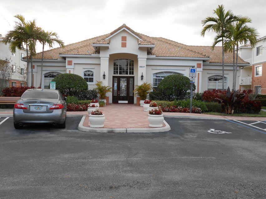 A beige building with a tiled roof and a paved walkway leading to the entrance — 9905 Baywinds Boulevard # 2202, West Palm Beach FL 33411, WEST PALM BEACH, FL