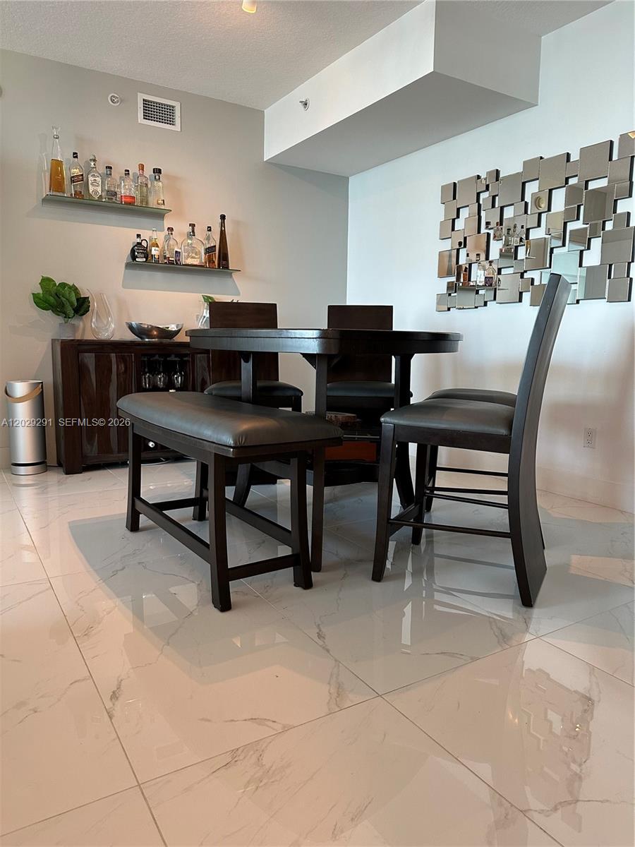 A dining area features a dark wood table, chairs, a bench, and wall-mounted shelves — 325 S Biscayne Blvd # 4119, Miami FL 33131, MIAMI, FL