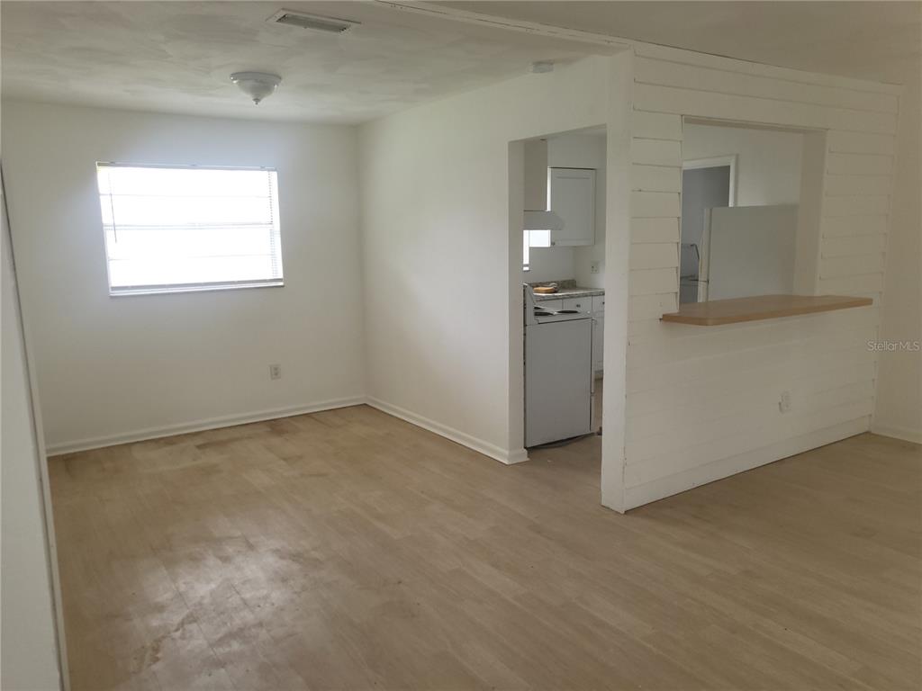 An interior view shows a dining area with light wood flooring and a kitchen pass-through — 2185 NW 3RD STREET, OKEECHOBEE, FL