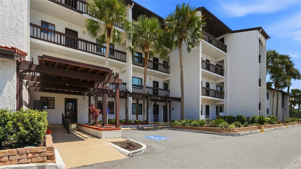 A screened-in patio features a dining set, a storage door, and a waterfront view — 1602 STICKNEY POINT ROAD UNIT 2-104, SARASOTA, FL