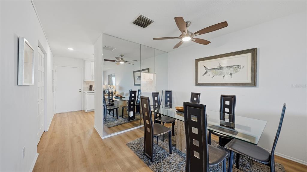 A living room features a gray sofa, two armchairs, a leather ottoman, and sliding glass doors — 1602 STICKNEY POINT ROAD UNIT 2-104, SARASOTA, FL