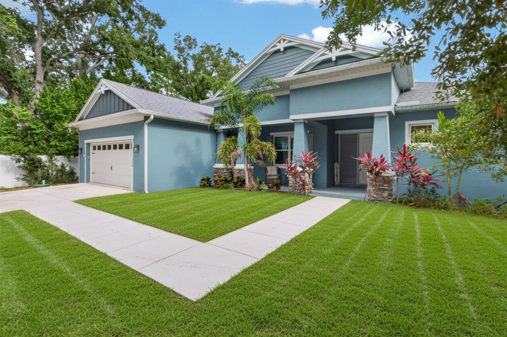 A blue single-story house with a garage, front porch, and a manicured lawn — 11560 110TH AVENUE, LARGO, FL