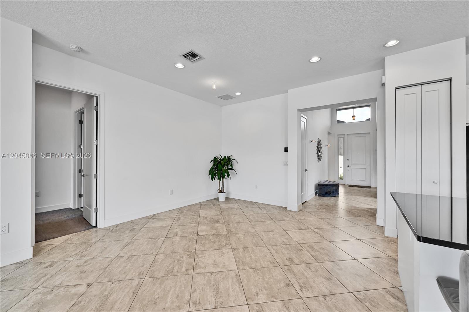A bright, tiled room features white walls, recessed lighting, and an entryway in the background — 9706 Celtic Sea Ln, Delray Beach FL 33446, DELRAY BEACH, FL