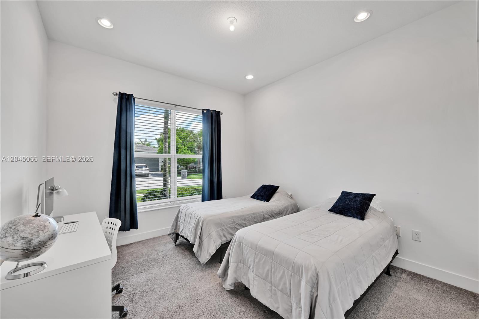 A bedroom features two twin beds, a white desk, and a window with blue curtains — 9706 Celtic Sea Ln, Delray Beach FL 33446, DELRAY BEACH, FL