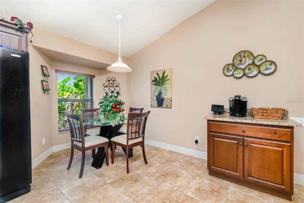 A dining area features a glass table, four chairs, a coffee station, and tile flooring — 2239 OLD BURNT STORE ROAD N, CAPE CORAL, FL