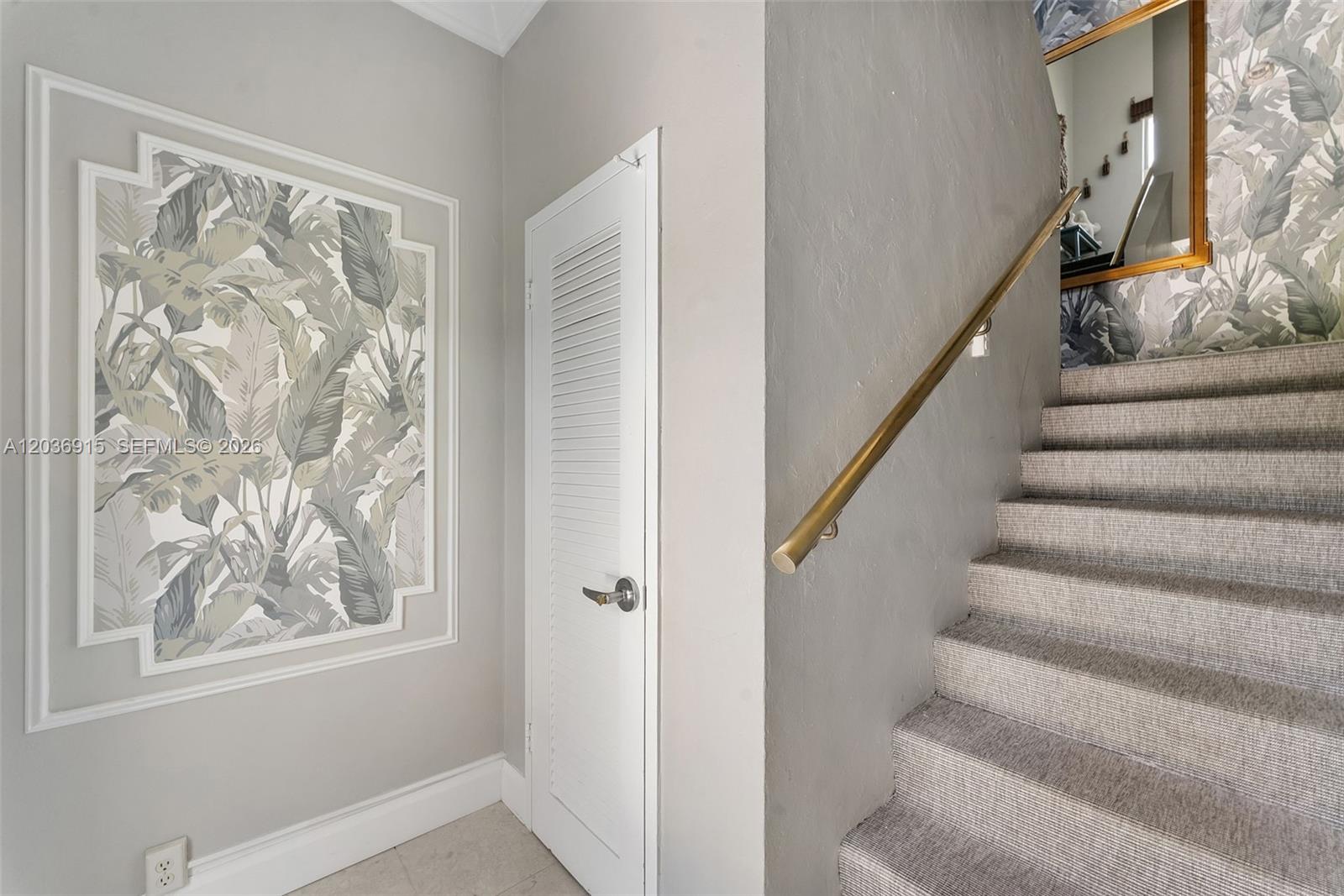 A staircase with carpeted steps and a brass handrail sits beside a louvered door — 120 N Ocean Blvd # 6, Delray Beach FL 33483, DELRAY BEACH, FL