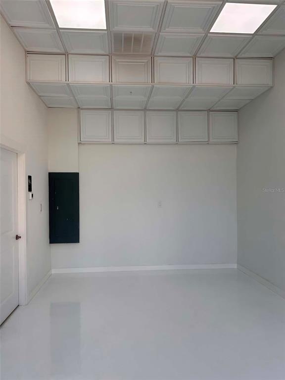 A room with white walls, a glossy floor, and a drop ceiling with recessed lighting — 1558 4TH STREET UNIT 104, SARASOTA, FL