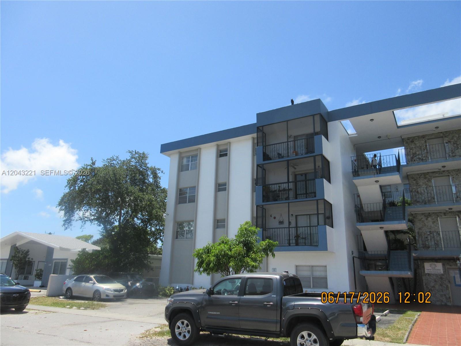 A multi-story apartment building with screened balconies and an adjacent parking area — 1230 NE 139th St # 309, North Miami FL 33161, NORTH MIAMI, FL