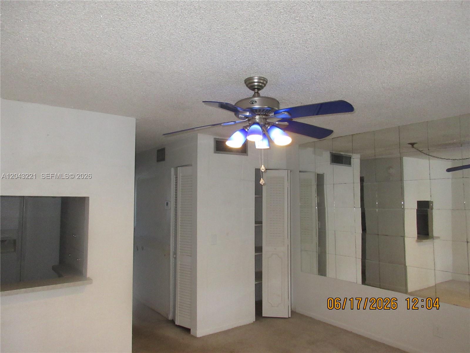 A room features a ceiling fan, a mirrored wall, and open closet doors — 1230 NE 139th St # 309, North Miami FL 33161, NORTH MIAMI, FL