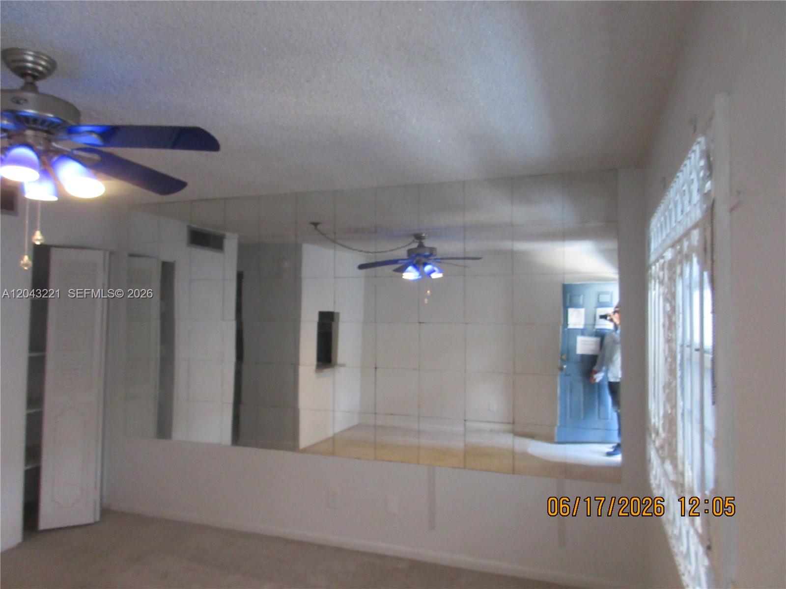 A room features a large mirrored wall, a ceiling fan, and a white door — 1230 NE 139th St # 309, North Miami FL 33161, NORTH MIAMI, FL