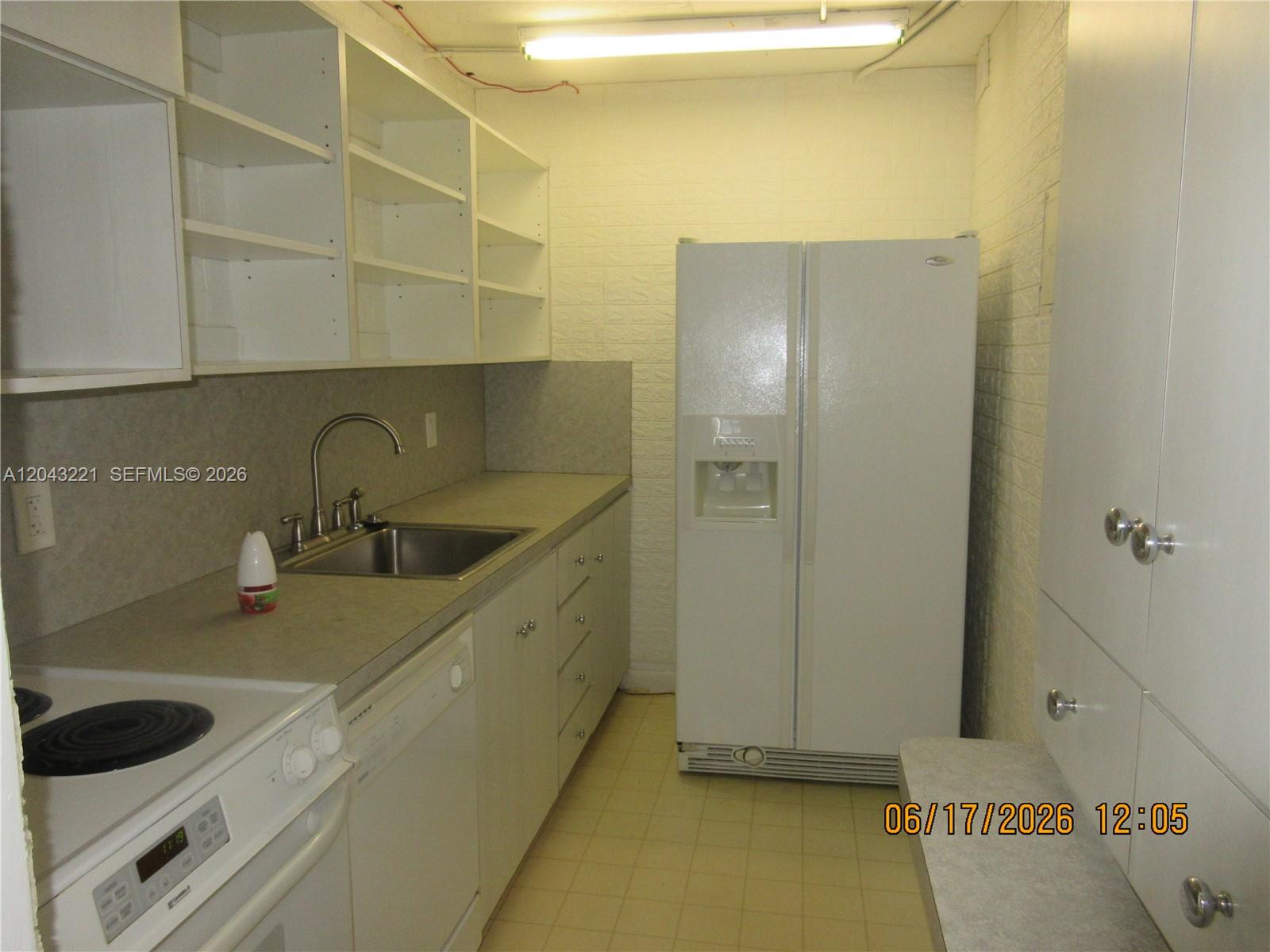 A kitchen features white cabinets, open shelving, a sink, a dishwasher, and a refrigerator — 1230 NE 139th St # 309, North Miami FL 33161, NORTH MIAMI, FL