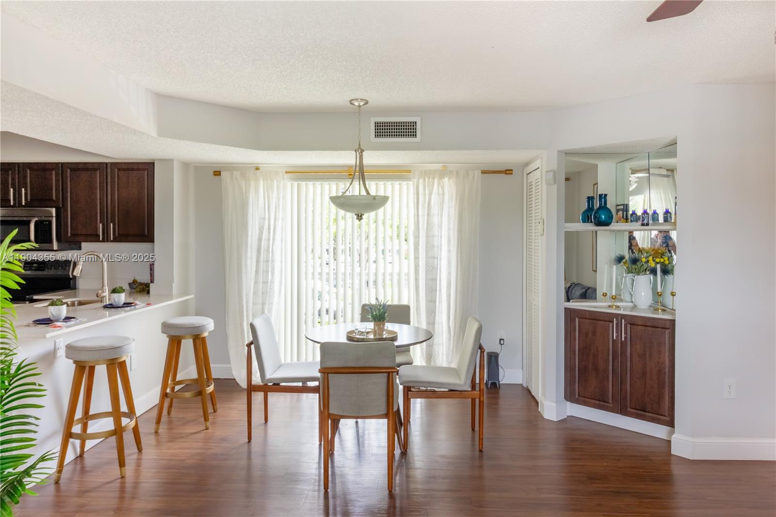 A dining area with a round table, four chairs, and a built-in mirrored wet bar — 17230 NW 64th Ave, Miami Lakes FL 33015, MIAMI LAKES, FL