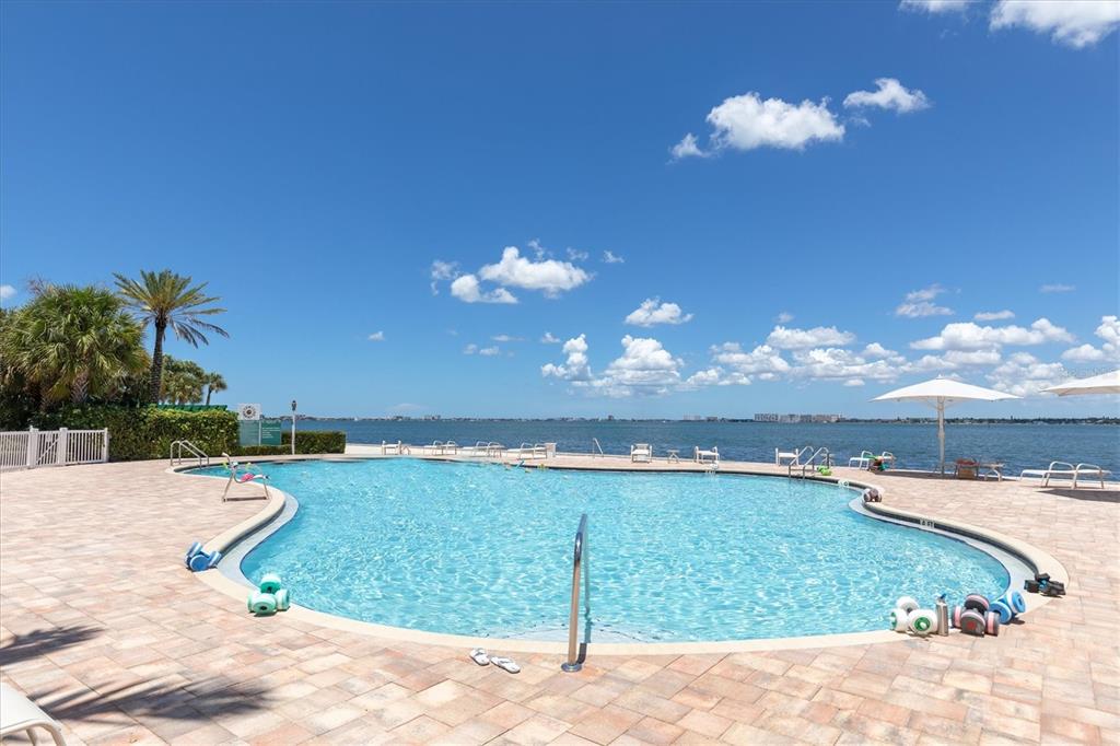 A modern kitchen features white cabinets, a dark blue island, and granite countertops with water views — 4993 BACOPA LANE S UNIT 705, ST PETERSBURG, FL