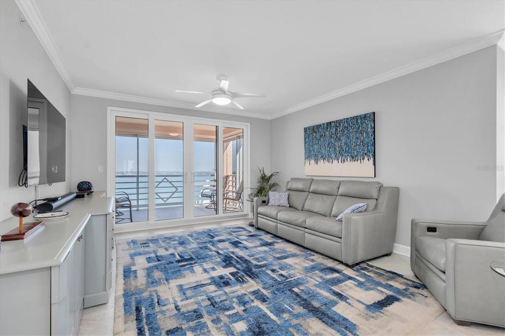 A screened-in balcony overlooks a bay with a view of distant buildings and a bridge — 4993 BACOPA LANE S UNIT 705, ST PETERSBURG, FL