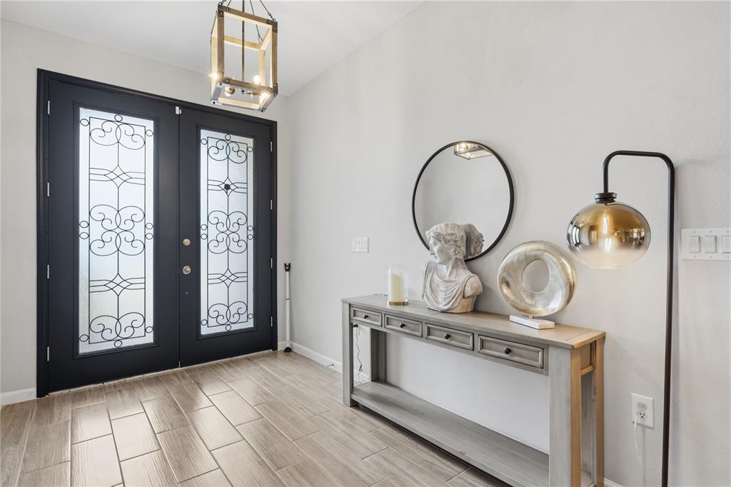An entryway features a black double door, a wooden console table, and a modern pendant light — 600 AVILA PLACE, HOWEY IN THE HILLS, FL