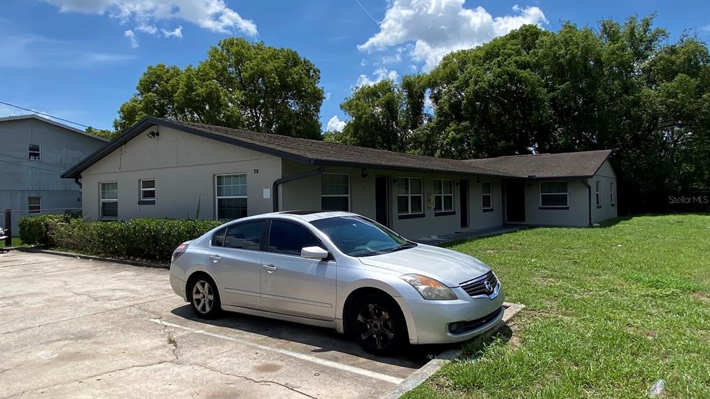 A silver sedan is parked in front of a single-story multi-unit residential building — 118 EATON STREET UNIT 4, EATONVILLE, FL