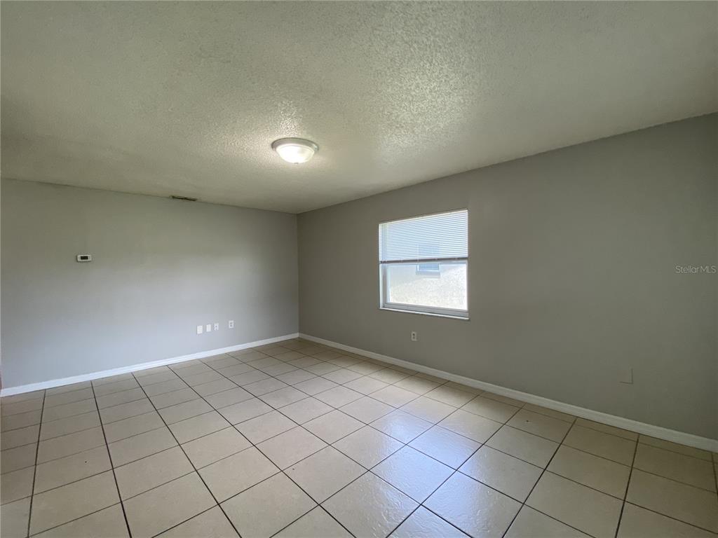 An empty room with gray walls, a tiled floor, and a single window — 118 EATON STREET UNIT 4, EATONVILLE, FL