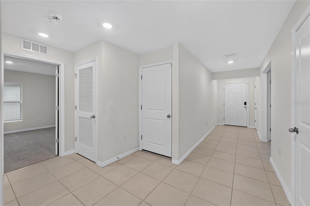 A tiled entryway leads to a front door, a closet, and a bedroom doorway — 1102 COASTAL HAMMOCK AVENUE, RUSKIN, FL