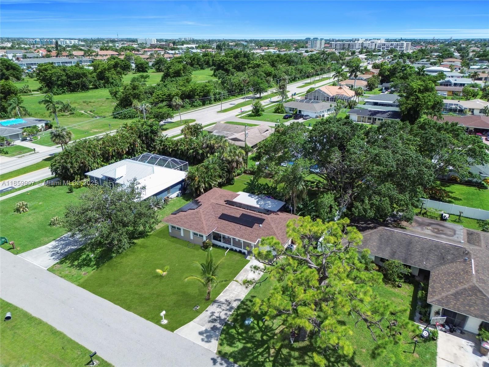 An aerial view shows a residential house with solar panels on a brown shingled roof — 246 SE 44th st, Cape Coral FL 33904, CAPE CORAL, FL