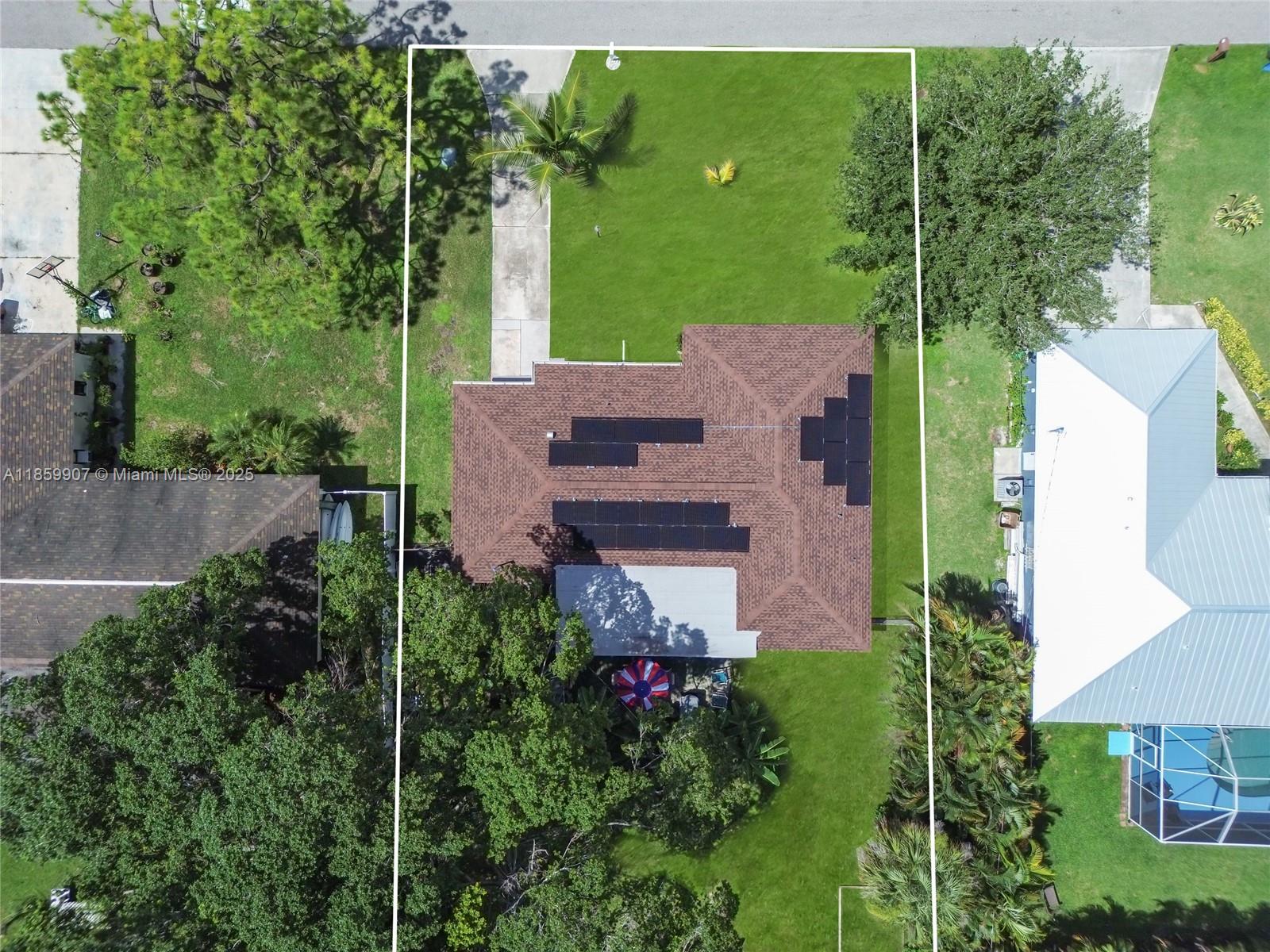 An aerial view shows a house with solar panels on a brown roof and a backyard — 246 SE 44th st, Cape Coral FL 33904, CAPE CORAL, FL