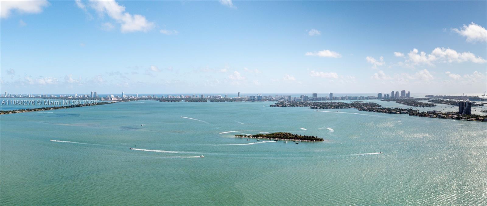 An aerial view shows a small island surrounded by blue water with a city skyline — 725 NE 24th St, Miami FL 33137, MIAMI, FL