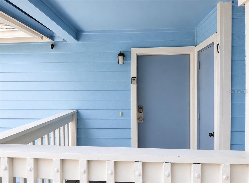 A light blue exterior wall features a door with a keypad and a white railing — 2747 N POINCIANA BOULEVARD UNIT 10, KISSIMMEE, FL