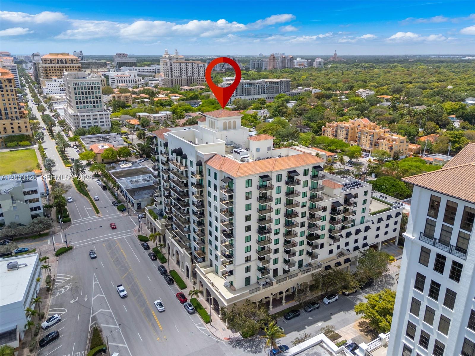 An aerial view shows a multi-story apartment building with balconies and a red-tiled roof — 1300 Ponce De Leon Blvd # 815, Coral Gables FL 33134, CORAL GABLES, FL