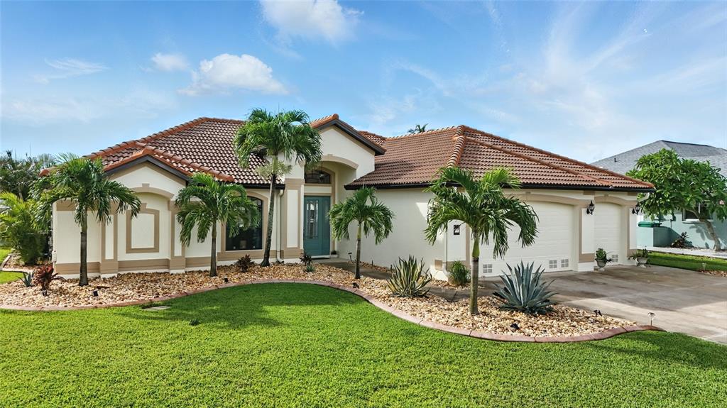 A single-story house with a tiled roof, palm trees, and a landscaped front yard — 9402 MIGUE CIRCLE, PORT CHARLOTTE, FL