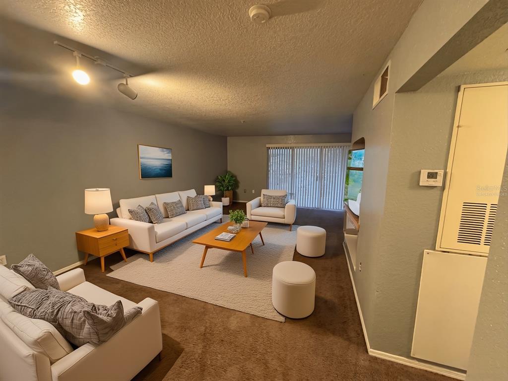 A living room features white sofas, a wooden coffee table, and a large area rug — 13838 FAIRWAY ISLAND DRIVE UNIT 1432, ORLANDO, FL