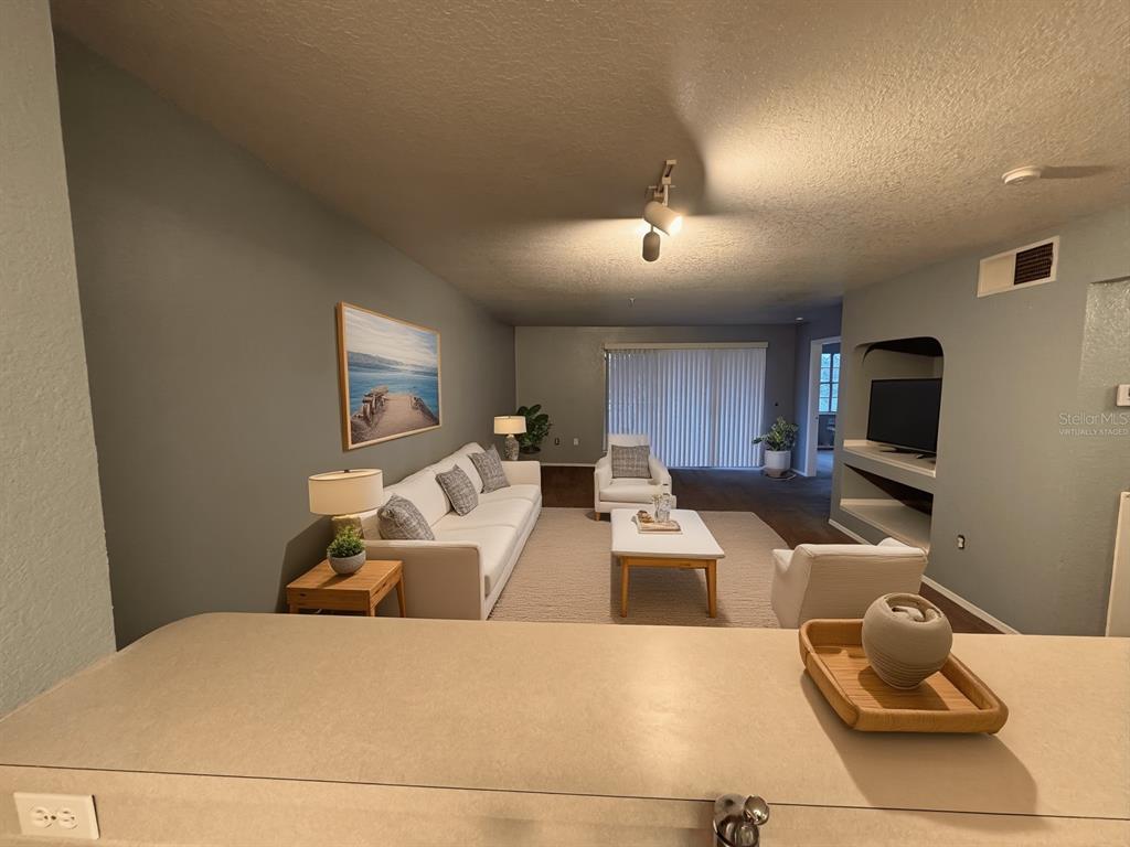 A living room with a sofa, armchairs, coffee table, and a built-in media niche — 13838 FAIRWAY ISLAND DRIVE UNIT 1432, ORLANDO, FL