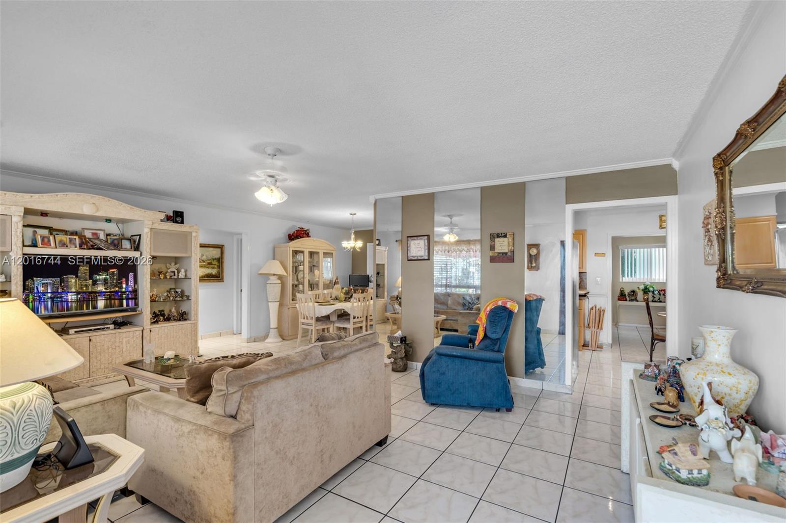 A living room features tiled floors, a large entertainment center, and a blue recliner — 5809 NW 83rd Ave, Tamarac FL 33321, TAMARAC, FL
