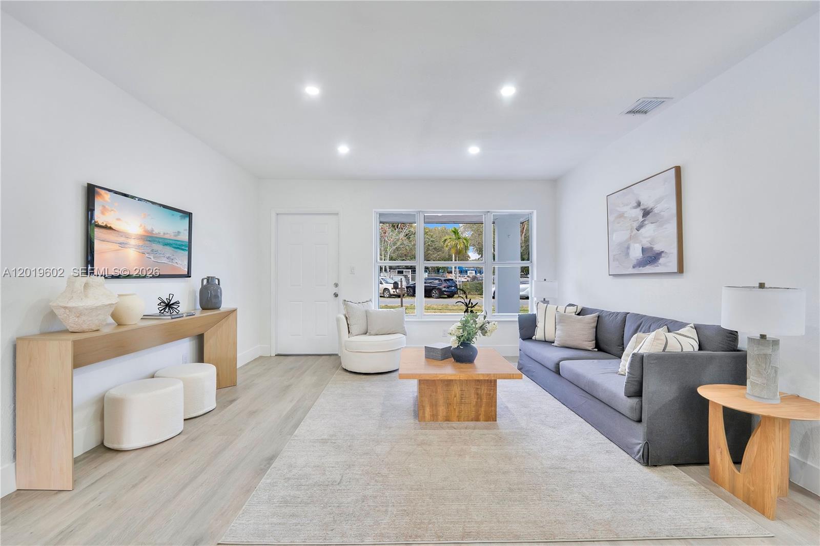 A living room features a gray sofa, a wooden coffee table, and a console table — 40 SE 3RD TERR, Dania Beach FL 33004, DANIA BEACH, FL