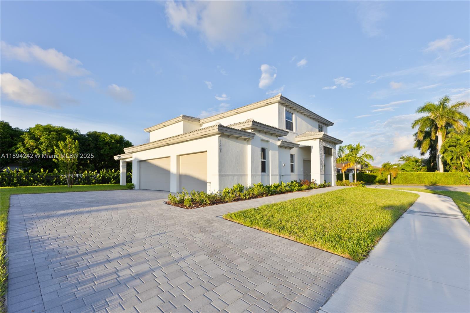 A two-story white house features a paved driveway, a two-car garage, and a lawn — 13203 SW 188th Ter, Miami FL 33177, MIAMI, FL