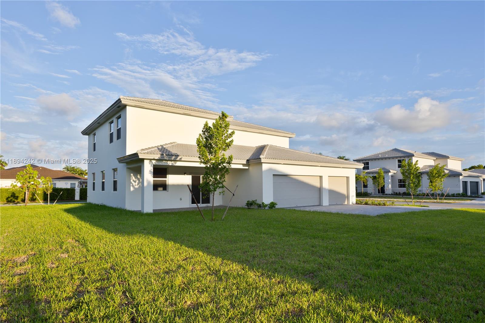 A two-story white house with a two-car garage and a large green lawn — 13203 SW 188th Ter, Miami FL 33177, MIAMI, FL