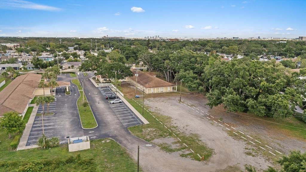 An aerial view shows a commercial building with a parking lot and surrounding trees — 4704 KELLY ROAD, TAMPA, FL