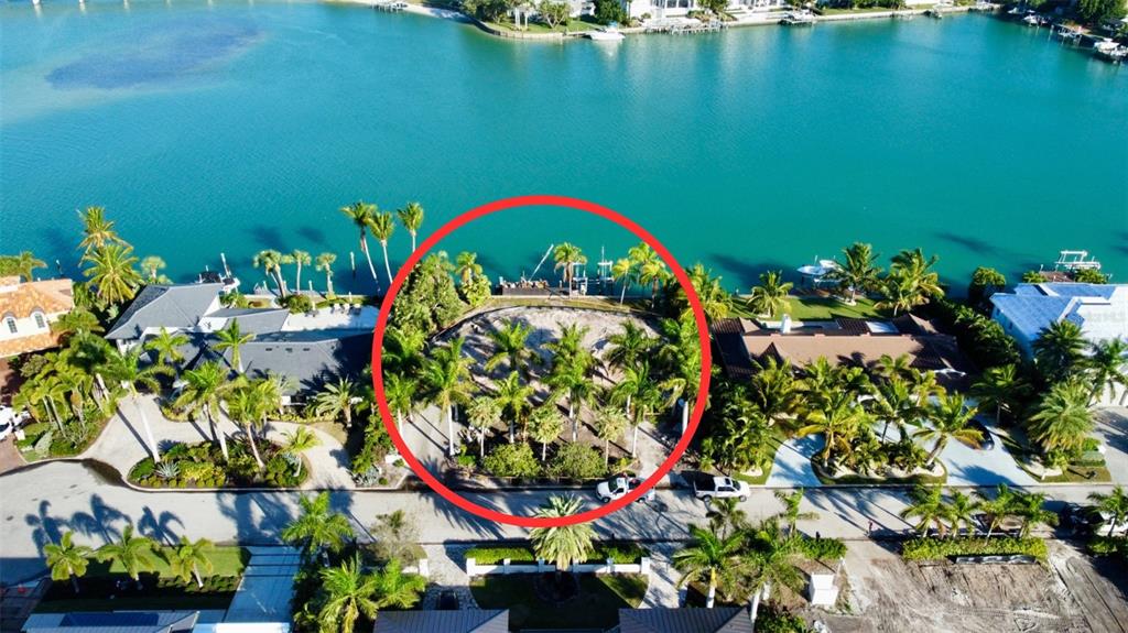An aerial view shows a vacant waterfront lot surrounded by palm trees and neighboring houses — 109 N WARBLER LANE, SARASOTA, FL