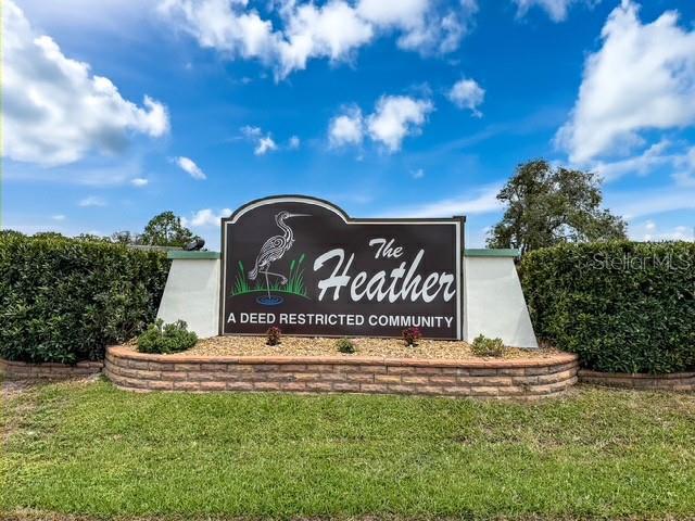 A sign for The Heather deed restricted community stands in front of manicured green hedges — 7686 ST ANDREWS BOULEVARD, WEEKI WACHEE, FL