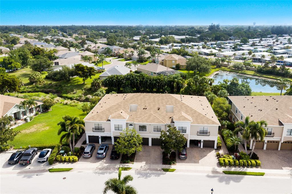 An aerial view shows a multi-unit townhouse complex with attached garages and surrounding residential landscaping — 7258 HAMILTON ROAD, BRADENTON, FL