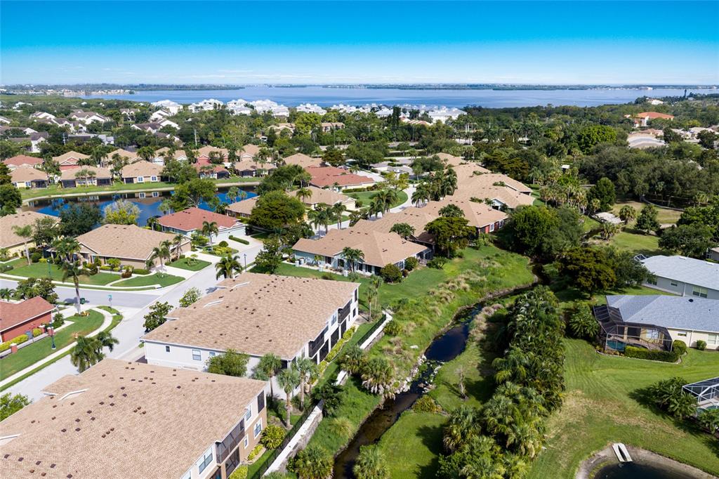 An aerial view shows a residential community with multiple houses, apartment buildings, and water features — 7258 HAMILTON ROAD, BRADENTON, FL
