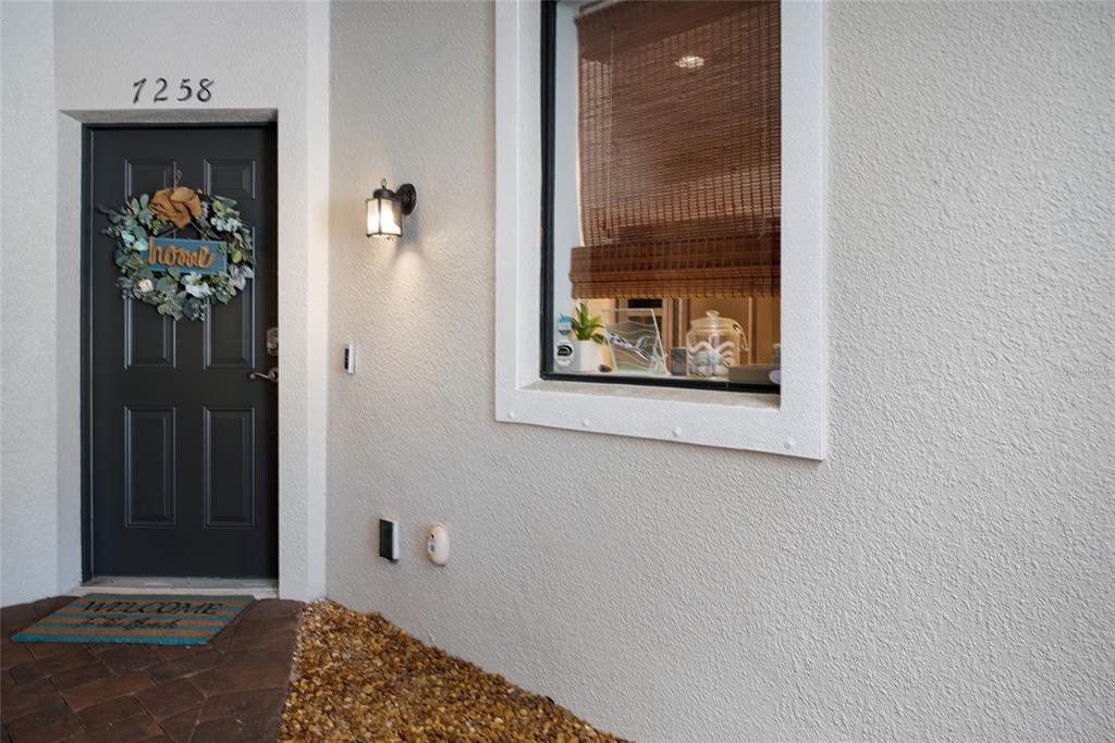A galley kitchen features white cabinets, granite countertops, stainless steel appliances, and tile flooring — 7258 HAMILTON ROAD, BRADENTON, FL