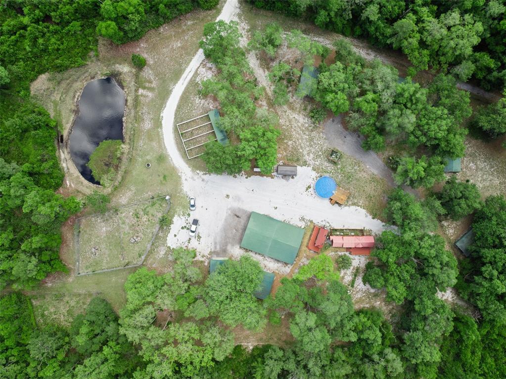 An aerial view shows a rural property with a pond, several outbuildings, and a pool — 1140 BUCKLES ROAD, PIERSON, FL