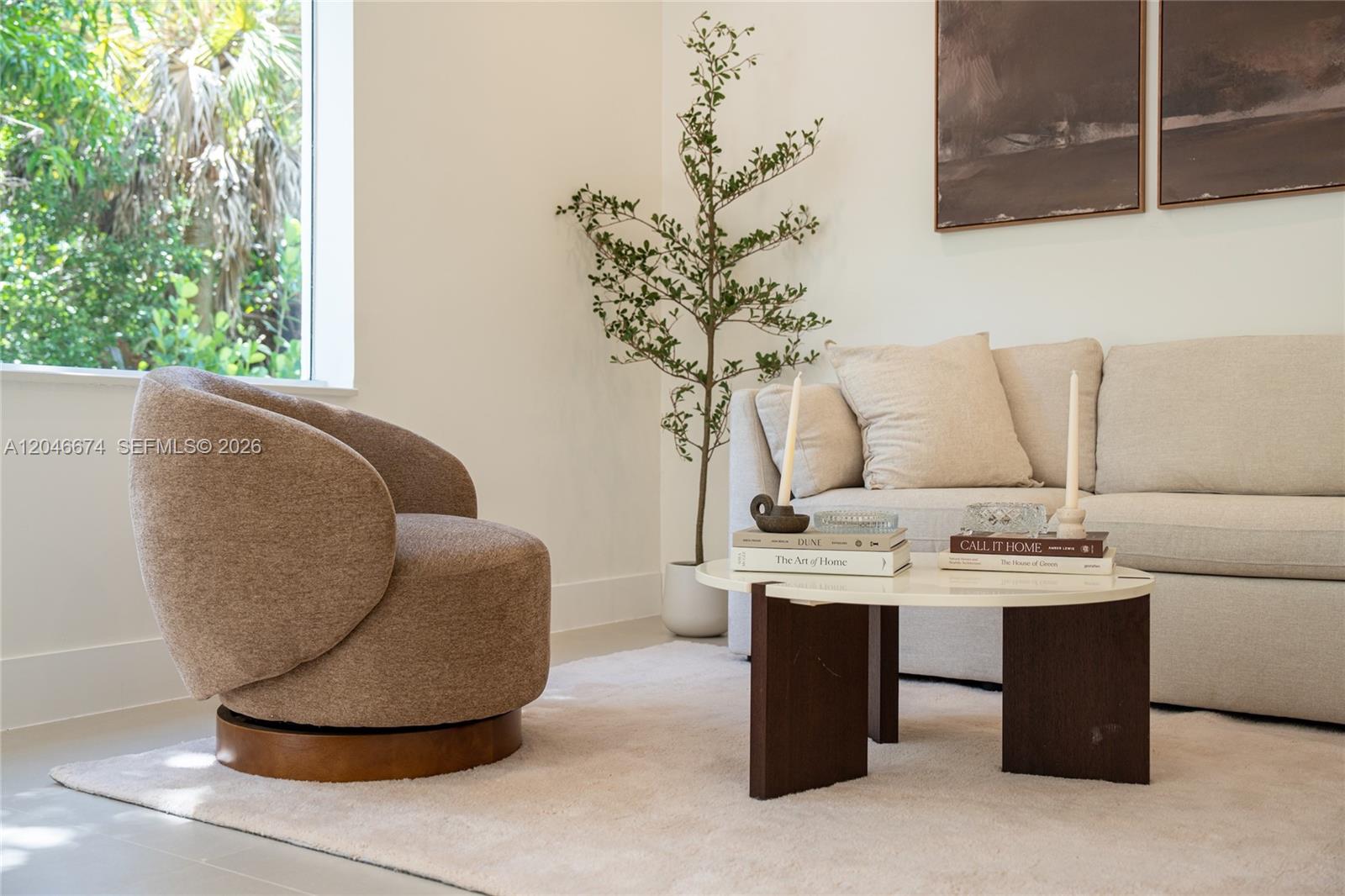 A living room features a beige sofa, a brown swivel chair, and a round coffee table — 8318 NE 3rd Ct, Miami FL 33138, MIAMI, FL
