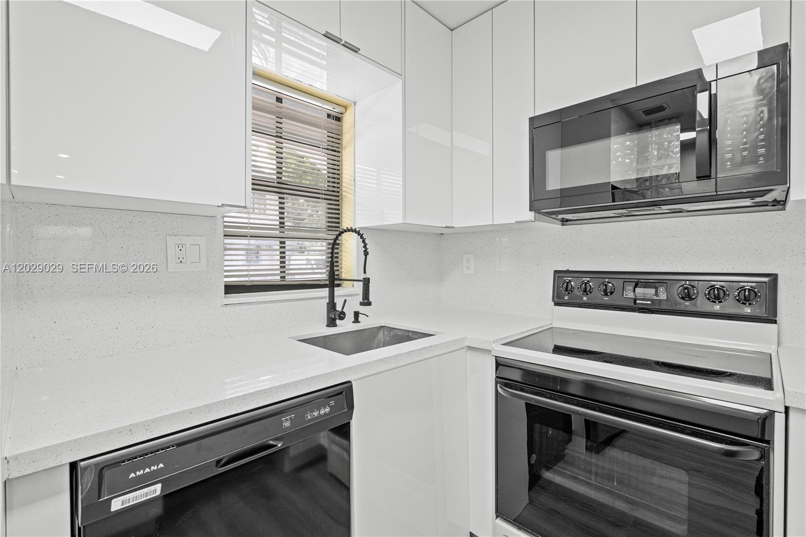 A modern kitchen features white cabinets, quartz countertops, a black dishwasher, and a black range — 12035 SW 18th St # 48, Miami FL 33175, MIAMI, FL