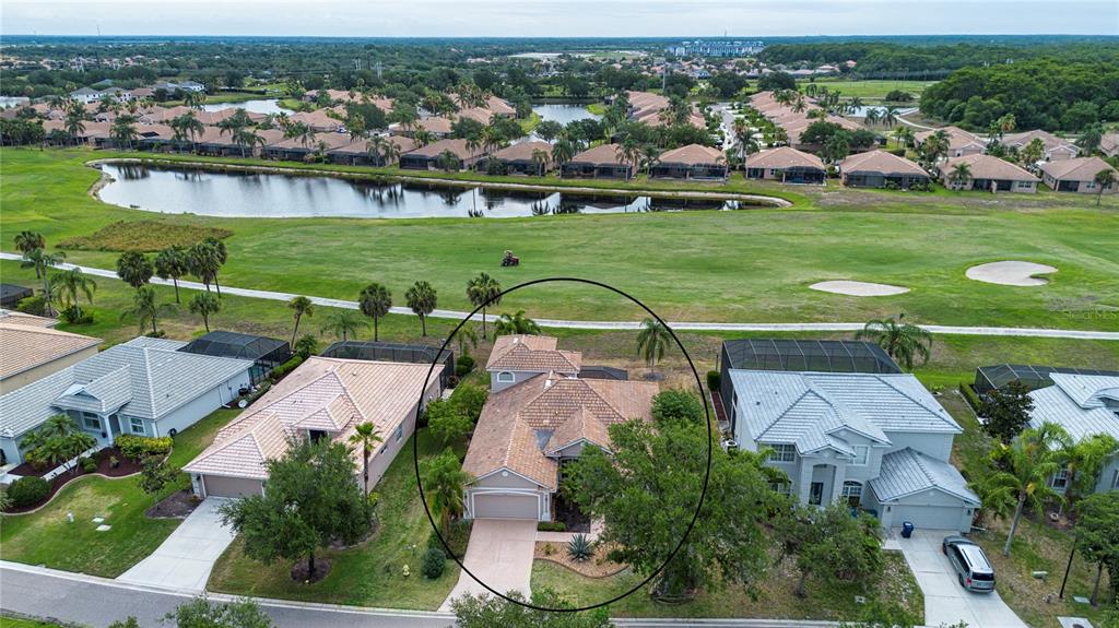 An aerial view shows a single-story house with a tiled roof and a two-car garage — 267 HERITAGE ISLES WAY, BRADENTON, FL